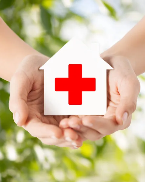 Руки, держа бумаги дом с Красного Креста — стоковое фото