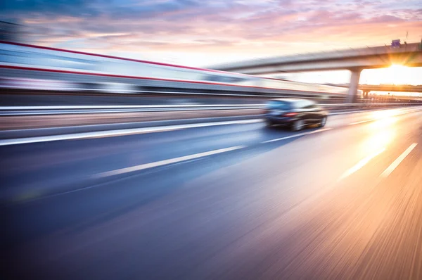 Автомобиль, едущий на автостраде на закате, размытом изображении — стоковое фото