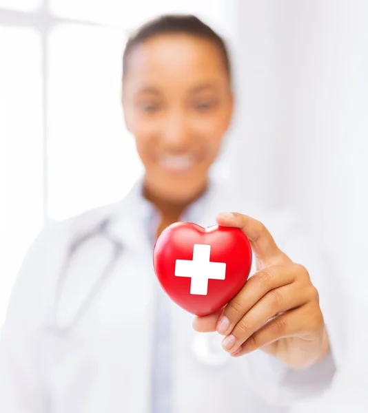 Женщина-врач держит сердце с символ Красного Креста — стоковое фото