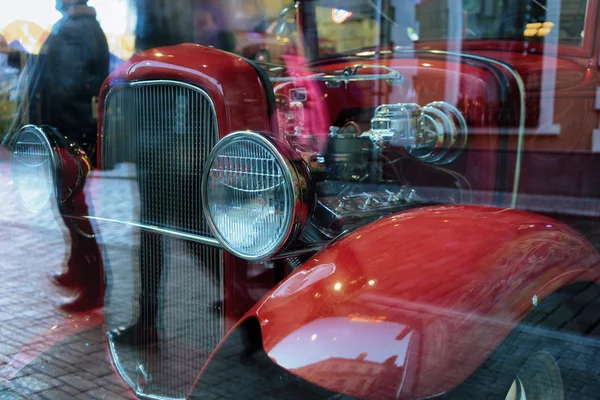 Ретро красный автомобиль с отражением в окне города — стоковое фото