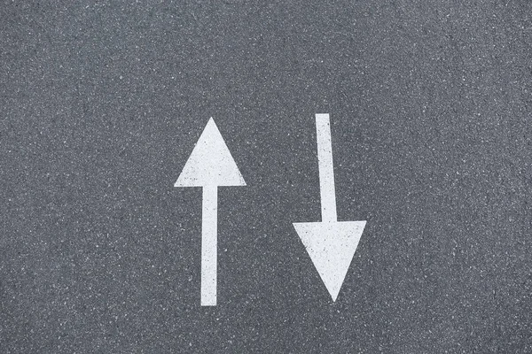 Стрелка знаков на асфальт дороги показаны направления движения, крупным планом — стоковое фото