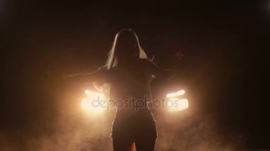 Возбужденные девушка танцует в Автомобильные фары ночью — стоковое видео