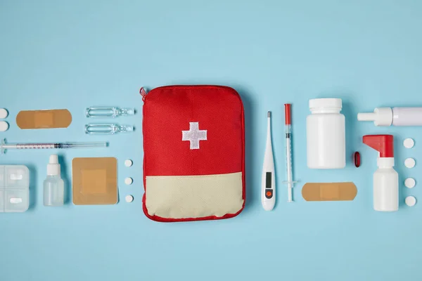 Top View Red First Aid Kit Bag Blue Surface Medical — стоковое фото