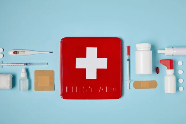 Top View Red First Aid Kit Box Blue Surface Medical — стоковое фото