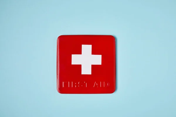 Top View Red First Aid Kit Box Blue Surface — стоковое фото