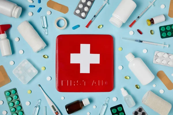 Top View Red First Aid Kit Box Blue Surface Surrounded — стоковое фото