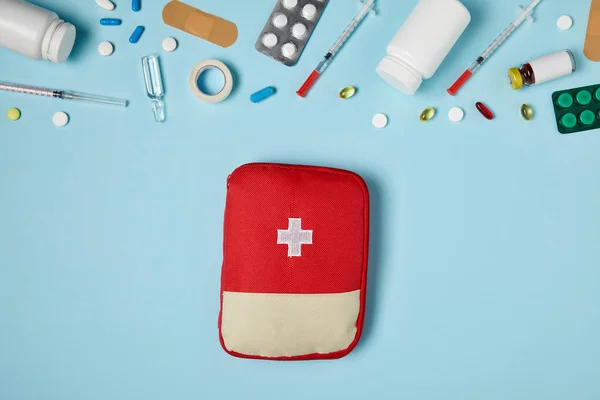 Top View Red First Aid Kit Bag Blue Surface Different — стоковое фото