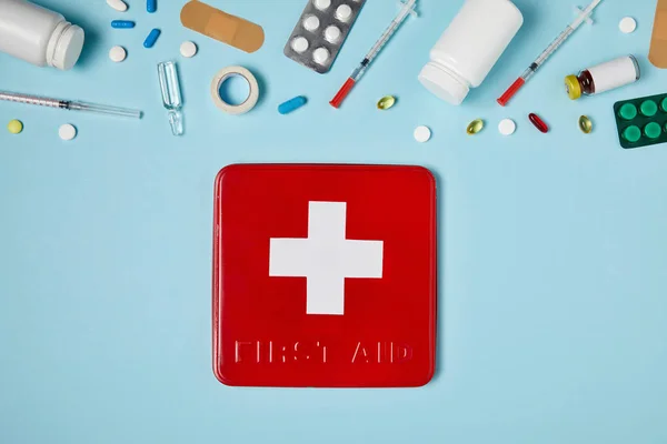 Top View Red First Aid Kit Box Blue Surface Various — стоковое фото